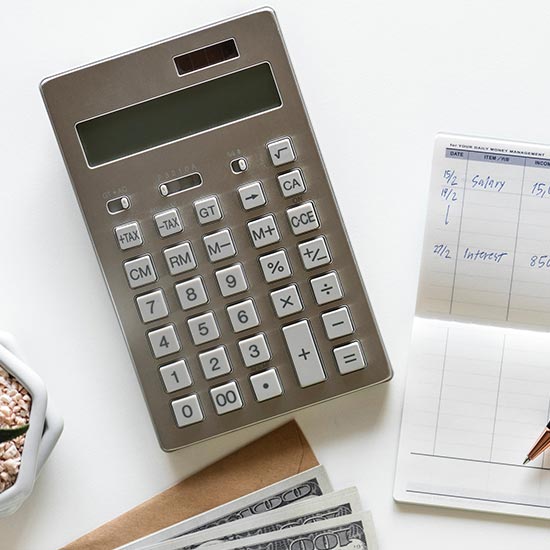 photo of a calculator, checkbook, and monetary bills