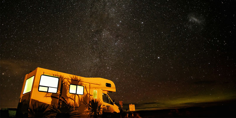 rv outdoors at night beneath the stars of the milky way