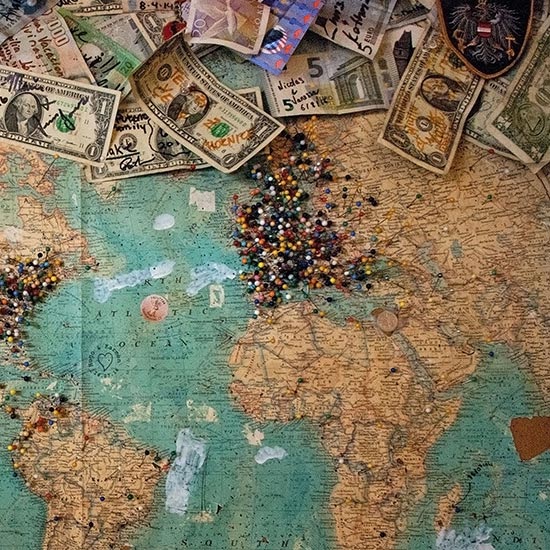 world map with pinned locations and money on top