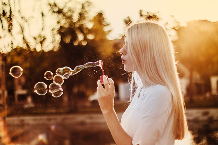 teenage girl blowing bubbles