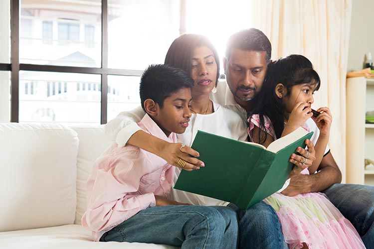 family reading a book together at home