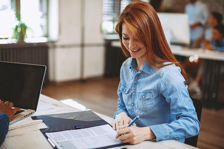 woman signing business account paperwork