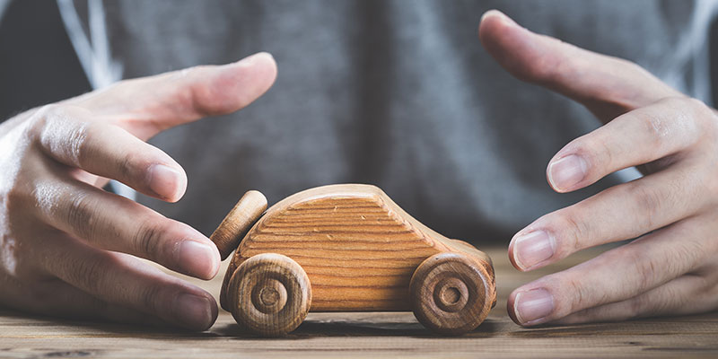 a man with a wooden toy car