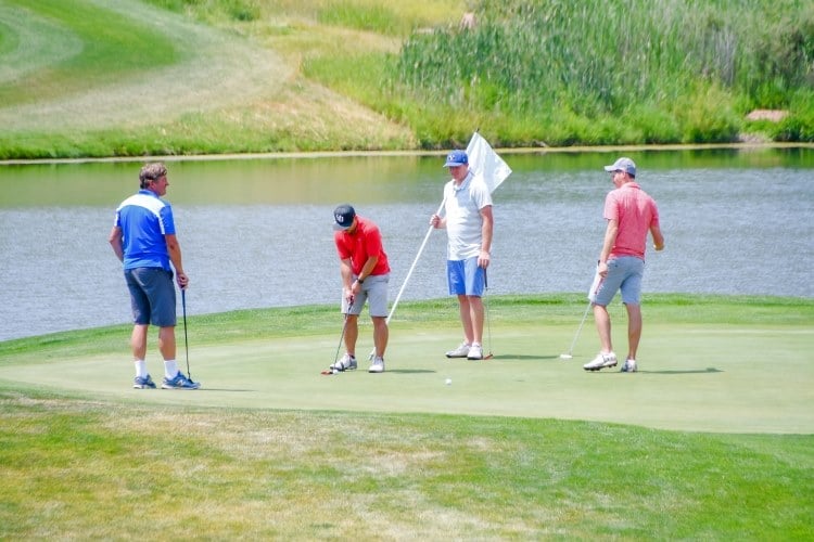 a group of four men playing golf