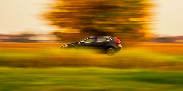 A car driving fast through the countryside.