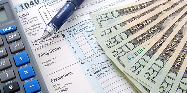 a calculator, pen, tax forms, and several twenty dollar bills