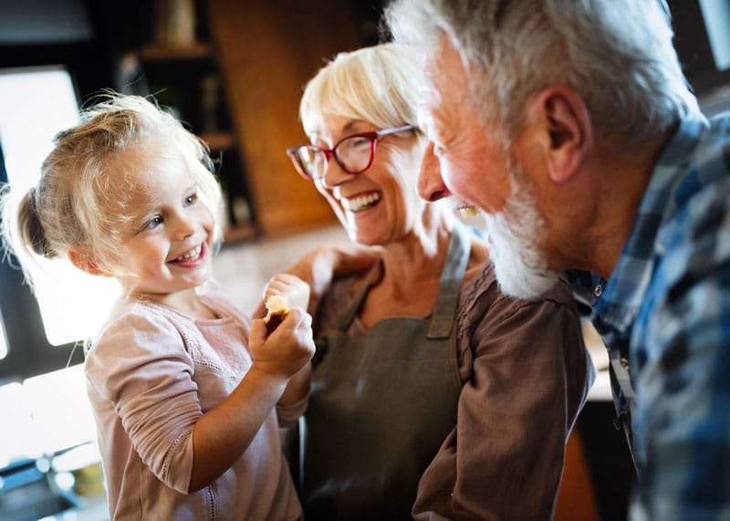 A young girl being held by her grandparents.